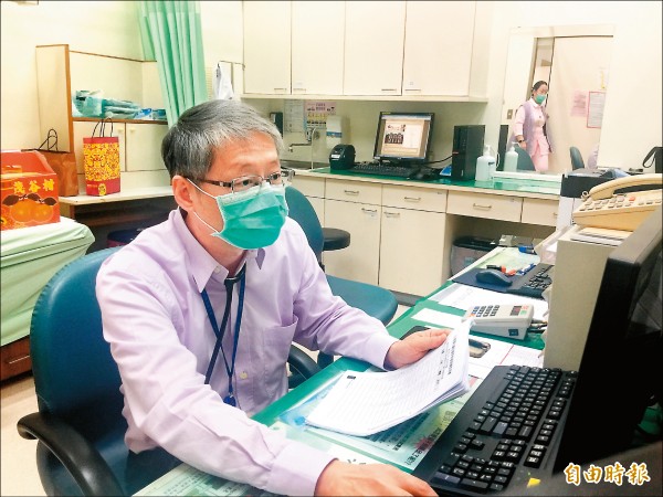 ▲許榮彬醫師檢視患者的血壓、心跳及體重紀錄表。（記者羅碧攝）