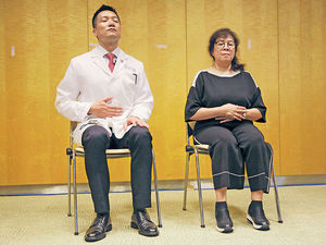 黃仰山教授（左）及馮女士（右）示範修習靜觀，馮女士指靜觀有助她放鬆入眠。（梁偉榮攝）
